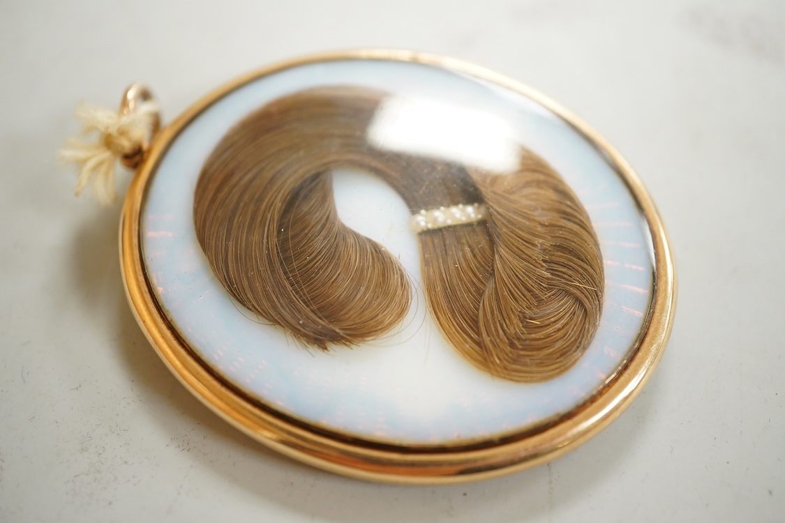 Regency School, Portrait miniature of a young gentleman, oval watercolour on ivory, housed in a yellow metal pendant frame with hairwork panel verso, glass loose, overall 7cm high - IVORY SUBMISSION BKCK66FM